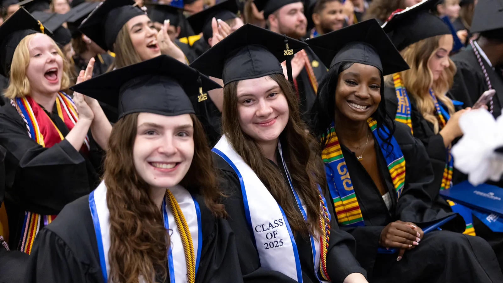Graduates smiling at commencement ceremony